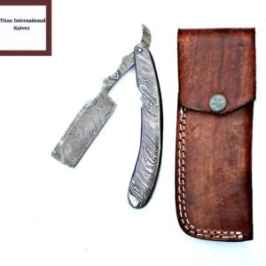 Open Damascus steel straight razor and a brown leather pouch with white stitching and a decorative snap on a white background
