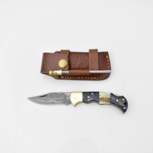 A Damascus steel folding knife with a multi-material handle and a brown leather sheath holding a fire starter on a white background