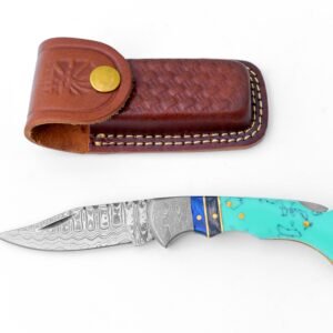 A folding knife with a patterned damascus steel blade and a teal handle with blue and black accents, next to a brown leather sheath with a snap
