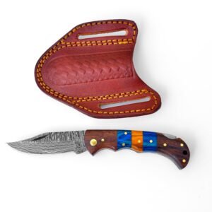 A folding knife with a Damascus blade and wood handle with blue and orange segments, beside a brown leather sheath with yellow stitching