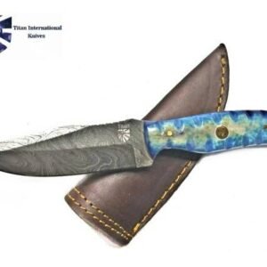 A Titan knife features a wavy Damascus steel blade and a vibrant blue and gold swirled handle, resting on its brown leather sheath