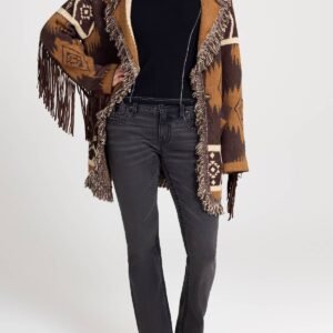 A person wears a brown and tan patterned fringe cardigan, black top, dark grey jeans, and white cowboy boots