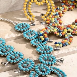 Several ornate Squash Blossom necklaces featuring turquoise, yellow, and multi-colored stones on silver-toned settings