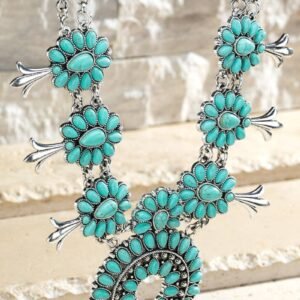 A silver-toned squash blossom necklace with multiple turquoise stone clusters and a large naja pendant