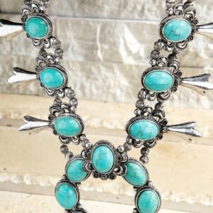 A silver-toned squash blossom necklace with numerous oval turquoise stones and silver blossom ornaments
