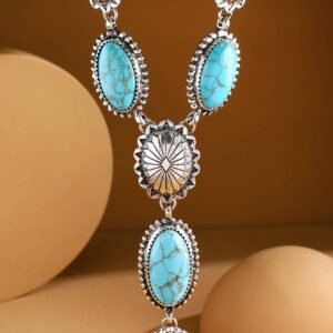 A silver-toned necklace with multiple oval and round turquoise stones, separated by decorative silver flower-like pieces