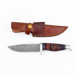 A Damascus steel knife with a layered wood handle lies below a brown leather sheath with an embossed tree design