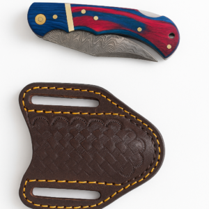 A folding knife with a Damascus steel blade and a blue and red marbled handle, beside a dark brown leather sheath with yellow stitching